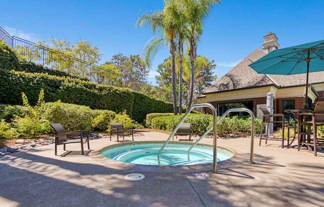 A pool surrounded by a patio with chairs and a table.