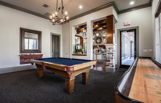 a game room with a pool table and a door to a bar