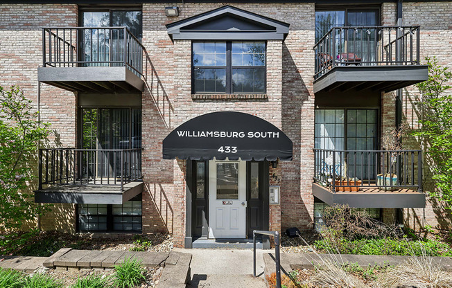 A brick building with a balcony and a door that says Williamsburg South 433.
