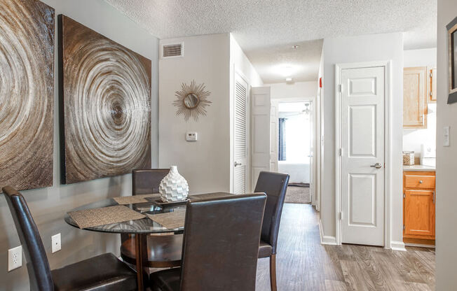 A dining room with a table and chairs.