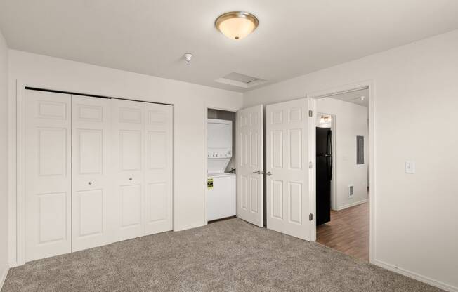 a bedroom with white closets and a door to the bathroom