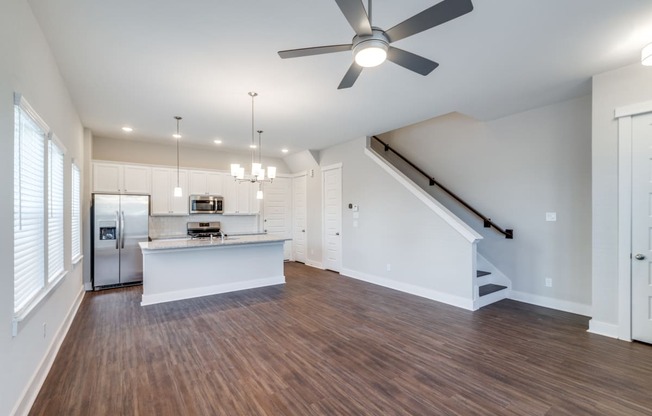 an open living room and kitchen with a ceiling fan