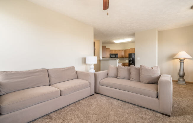 a living room with a couch and a chair and a kitchen