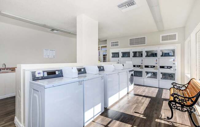 A laundry room with a row of washers and dryers.