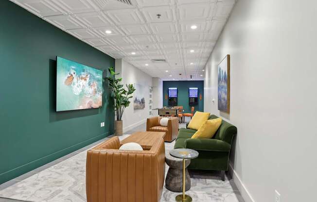 A long hallway with a green couch and a painting on the wall.