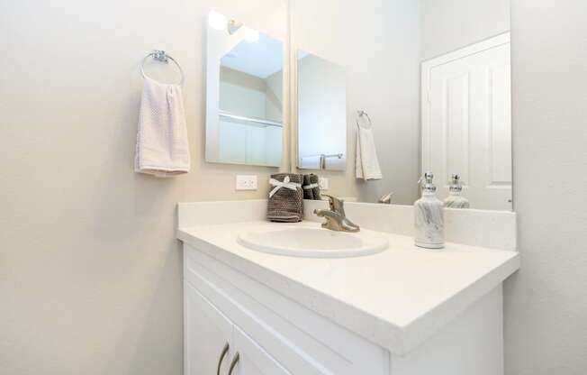 a white bathroom with a sink and a mirror