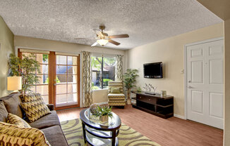 a living room with a ceiling fan and a large window