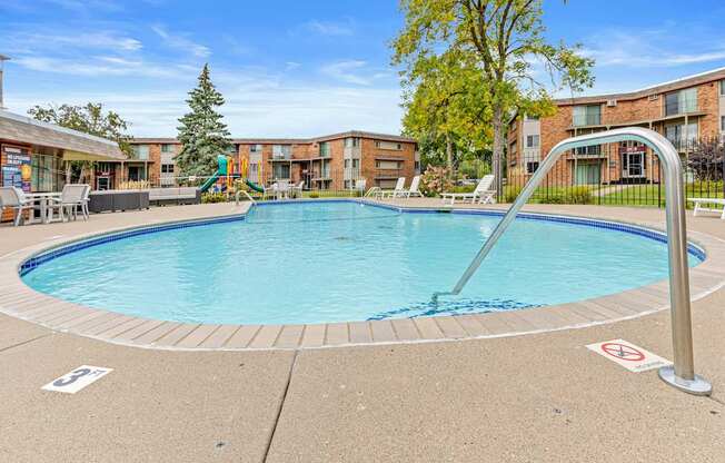 A swimming pool surrounded by a metal railing and a no swimming sign.