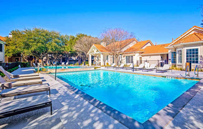 a swimming pool with chairs around it in front of a house at The Olivine, Texas, 78727