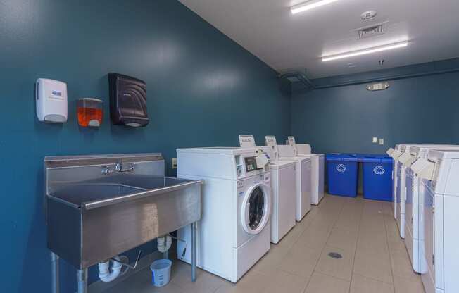 a laundry room with washes and washing machines and a sink