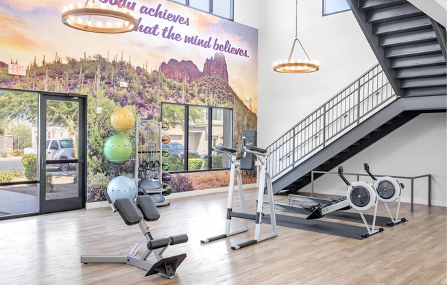 A gym with a staircase and exercise equipment.