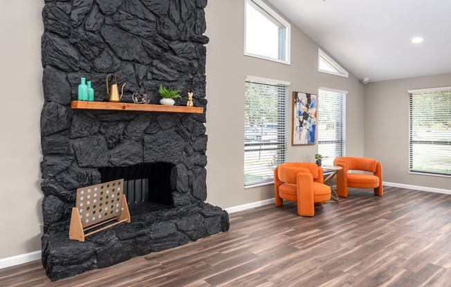 a living room with a fireplace and orange chairs