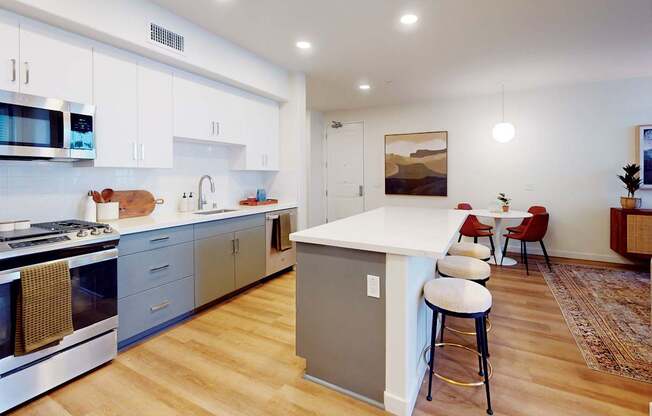 A kitchen with a white island and stools at The Villas at Anacapa Canyon, Camarillo, 93012