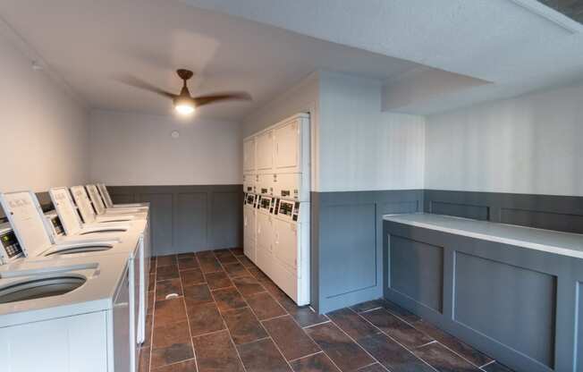 This is a photo of the 6 washers and dryers and folding area in the clothes care center at Princeton Court Apartments in the Vickery Meadow neighborhood of Dallas, Texas.