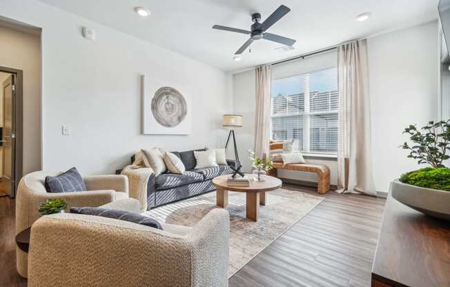 a living room with furniture and a ceiling fan