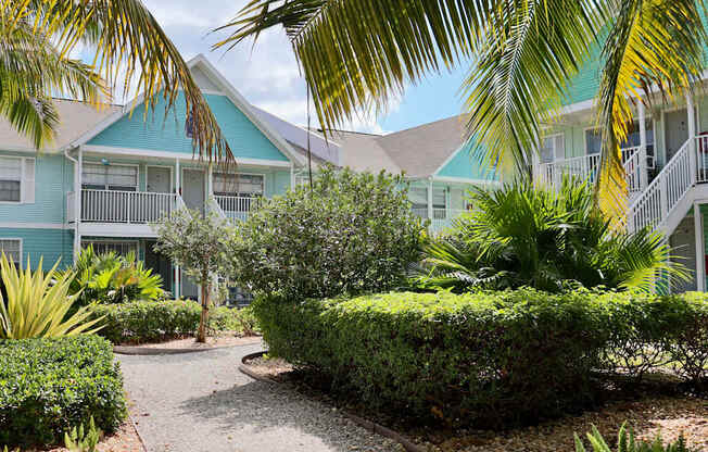 A pathway leads through a landscaped area in front of a row of houses.