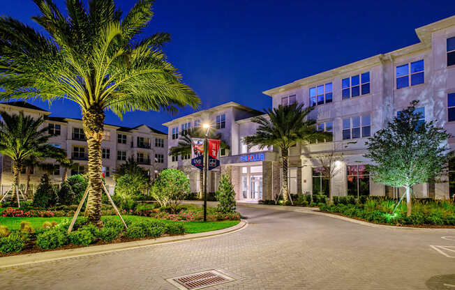 A palm tree stands in front of a building with a lit up sign that says "The Blue".