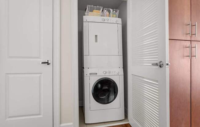A white washing machine is in a small laundry room.