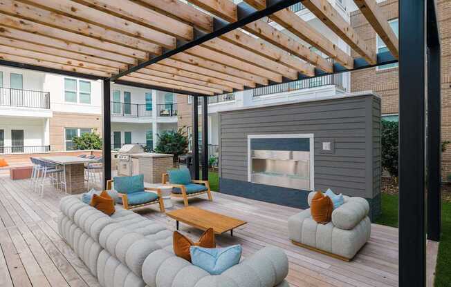 A wooden deck with a fireplace and seating area.
