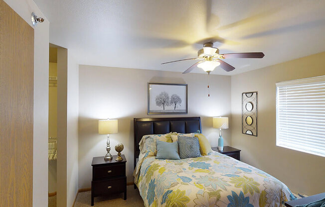 a bedroom with a bed and a ceiling fan