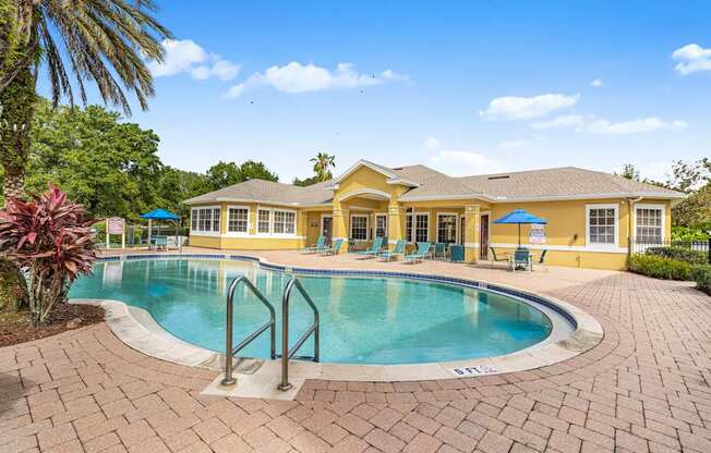 A large yellow house with a pool in the backyard.
