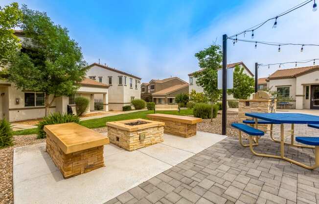 the backyard has a picnic table and benches and a fire pit