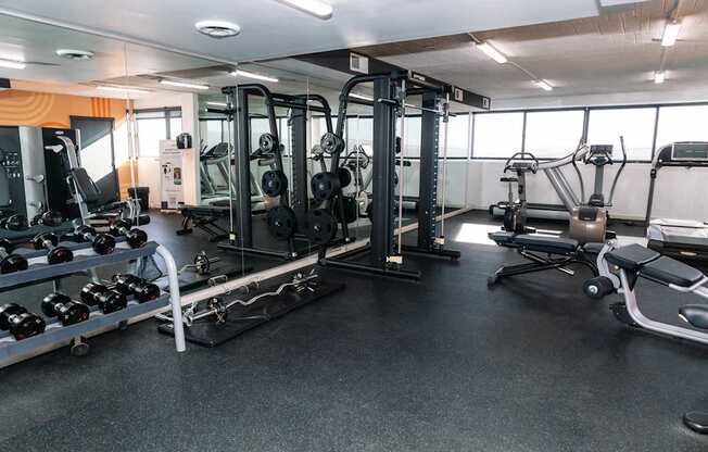A gym with a variety of equipment including weights and weight machines.