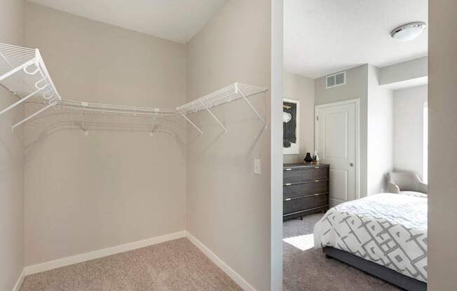 A bedroom with a white bed and a white closet.