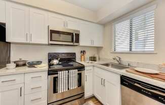 Kitchen with White Cabinets, Oven, Microwave, Window and Dishwasher at Silverstone Apartments, Davis, California