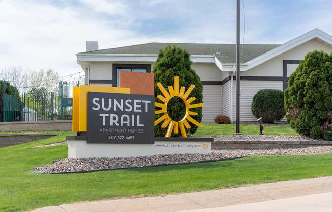 a sunset trail sign in front of a building with a house