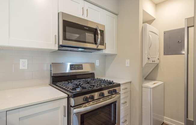 a kitchen with white cabinets and stainless steel appliances