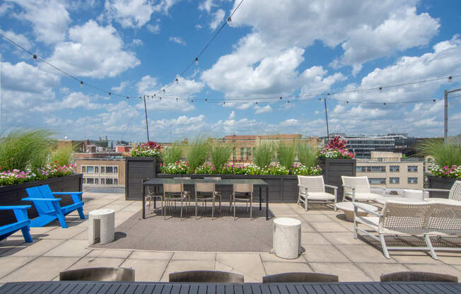 a rooftop patio with tables and chairs and a view of the city