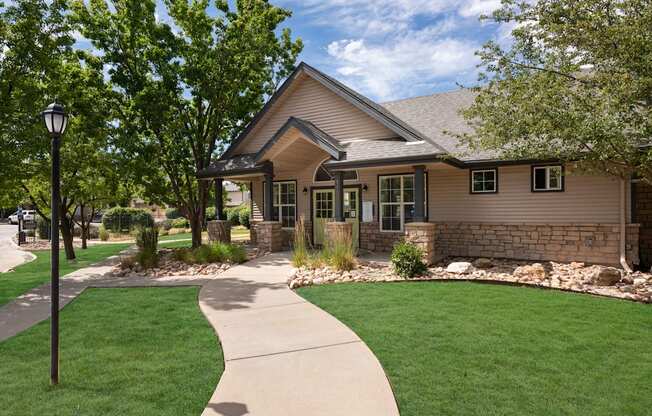 the front of a house with a sidewalk and lawn
