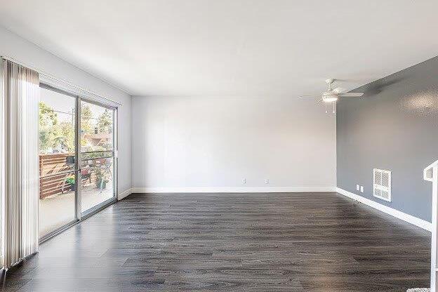 A spacious room with a sliding glass door leading to a balcony.