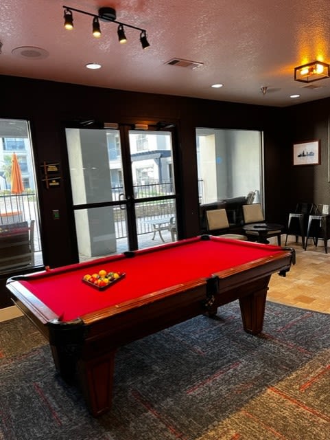 a red pool table in a room At Metropolitan Apartments in Little Rock, AR