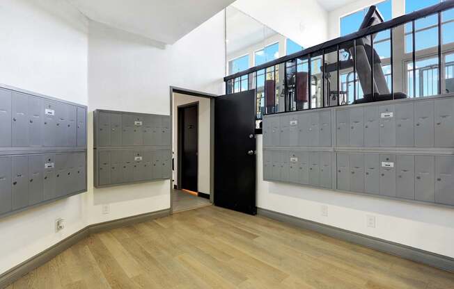 A room with a black door and a row of grey lockers.