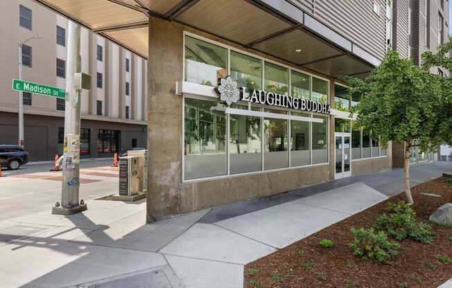 A building with a glass facade and a sign that reads "LAUGHING BUDDHA".
