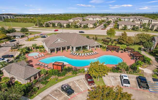 an aerial view of a swimming pool in a community with houses at Sladestone Shadow Creek, Pearland