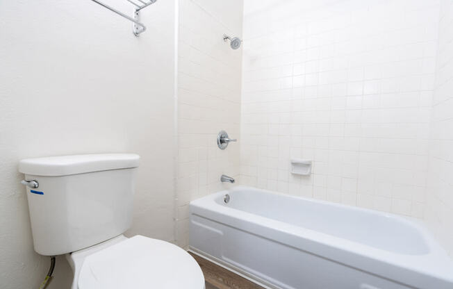 a white bathroom with a toilet and a tub