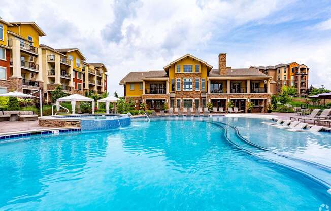 A large swimming pool in front of a resort-style building.