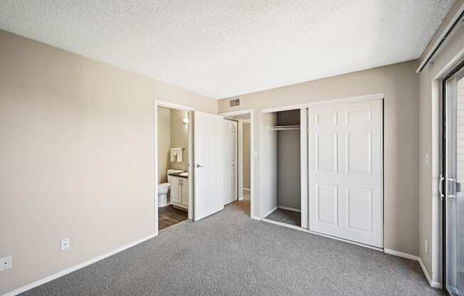 an empty bedroom with a closet and carpet flooring