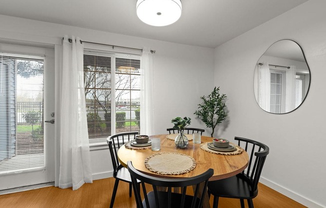 A dining room with a round table set for two.