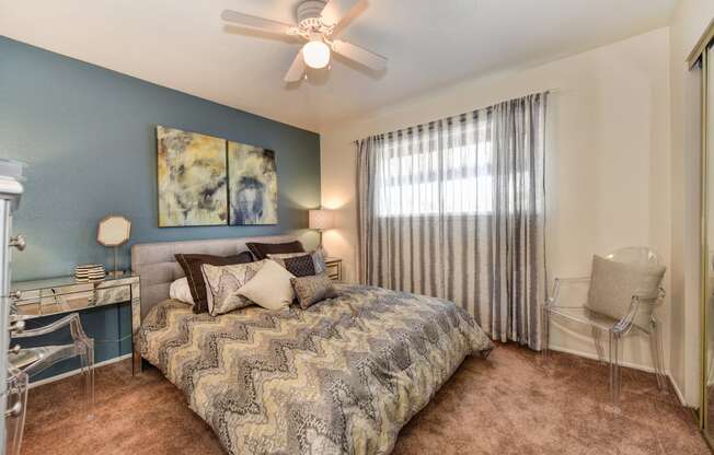 Olympus Park model home bedroom with carpet, window and ceiling fan.