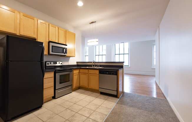 a kitchen with wooden cabinets and black appliances at 26 West, Managed by Buckingham Urban Living, Indianapolis