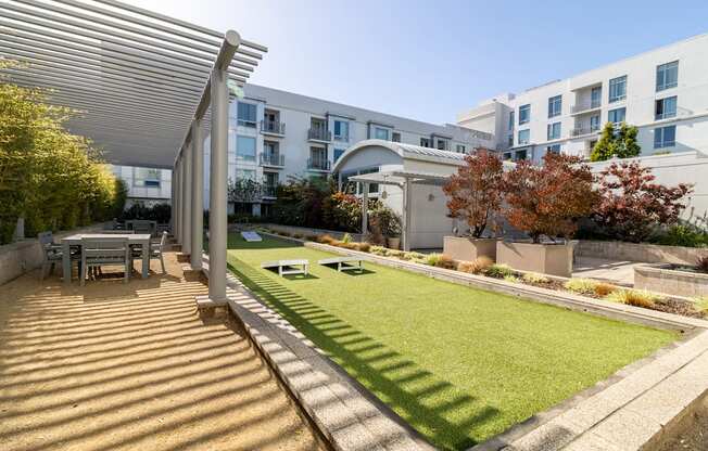 a backyard with a lawn and a table and chairs