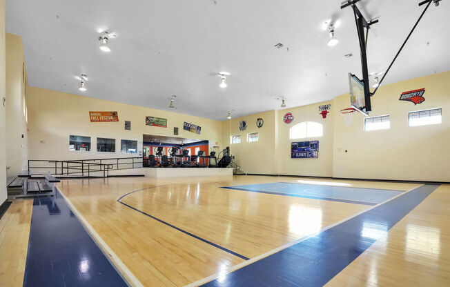 indoor basketball court with fitness equipment in the background
