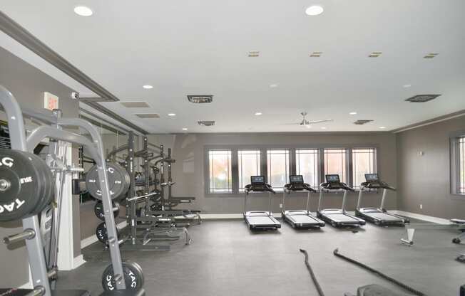 a gym with a lot of exercise equipment and windows