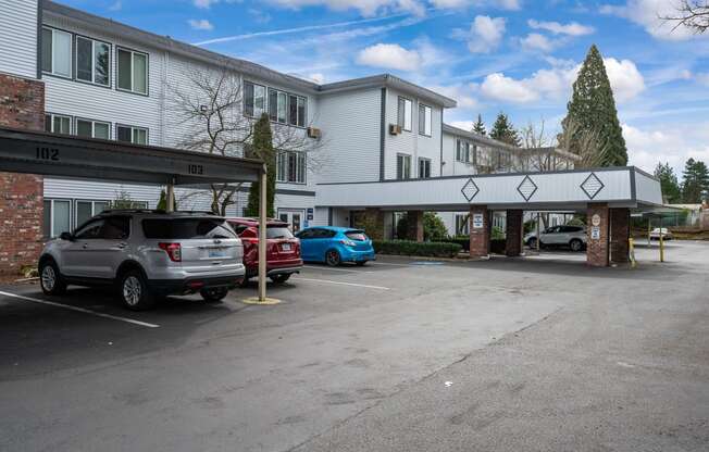 a parking lot with cars in front of a hotel