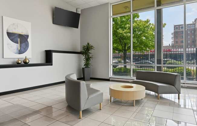 a lobby with two chairs and a table and a large window