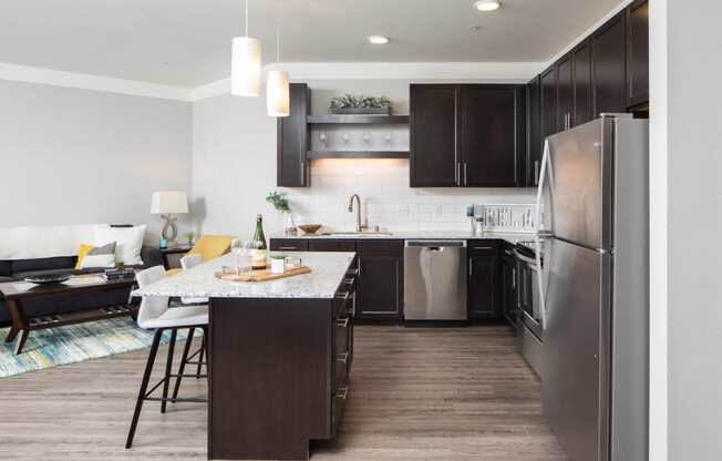 A modern kitchen with dark wood cabinets and a large island.